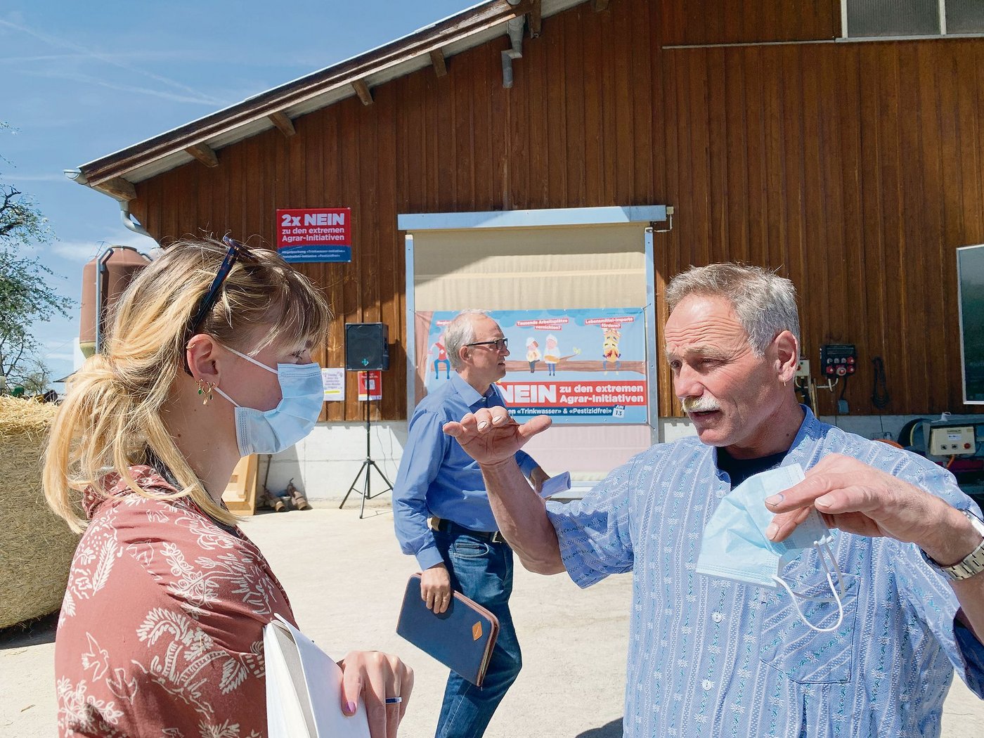 Landwirt Karl Meienberg erklärt einer Journalistin die Folgen der Pflanzenschutz-Initiativen auf seinem Bauernhof. Mitten im Bild Ständerat Peter Hegglin. (Bild Josef Scherer)