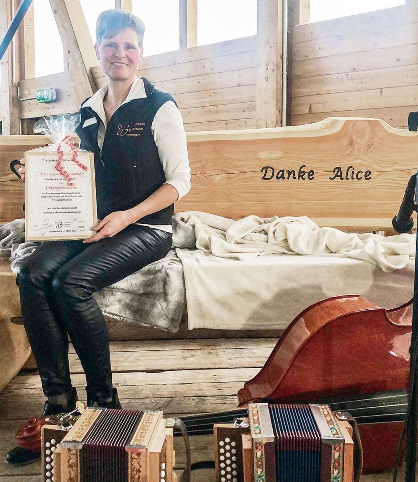 Die Ehrenpräsidentin Alice Gwerder sitzt auf ihrem Abschiedsgeschenk, einer geschnitzten Holzbank.