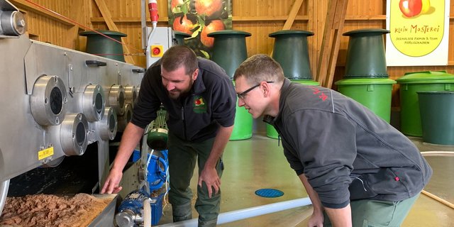 Pirmin Seeholzer (l.) und Christian Arnitz von der Kleinmosterei in Udligenswil begutachten den Saft aus der Bandpresse (Bild js)