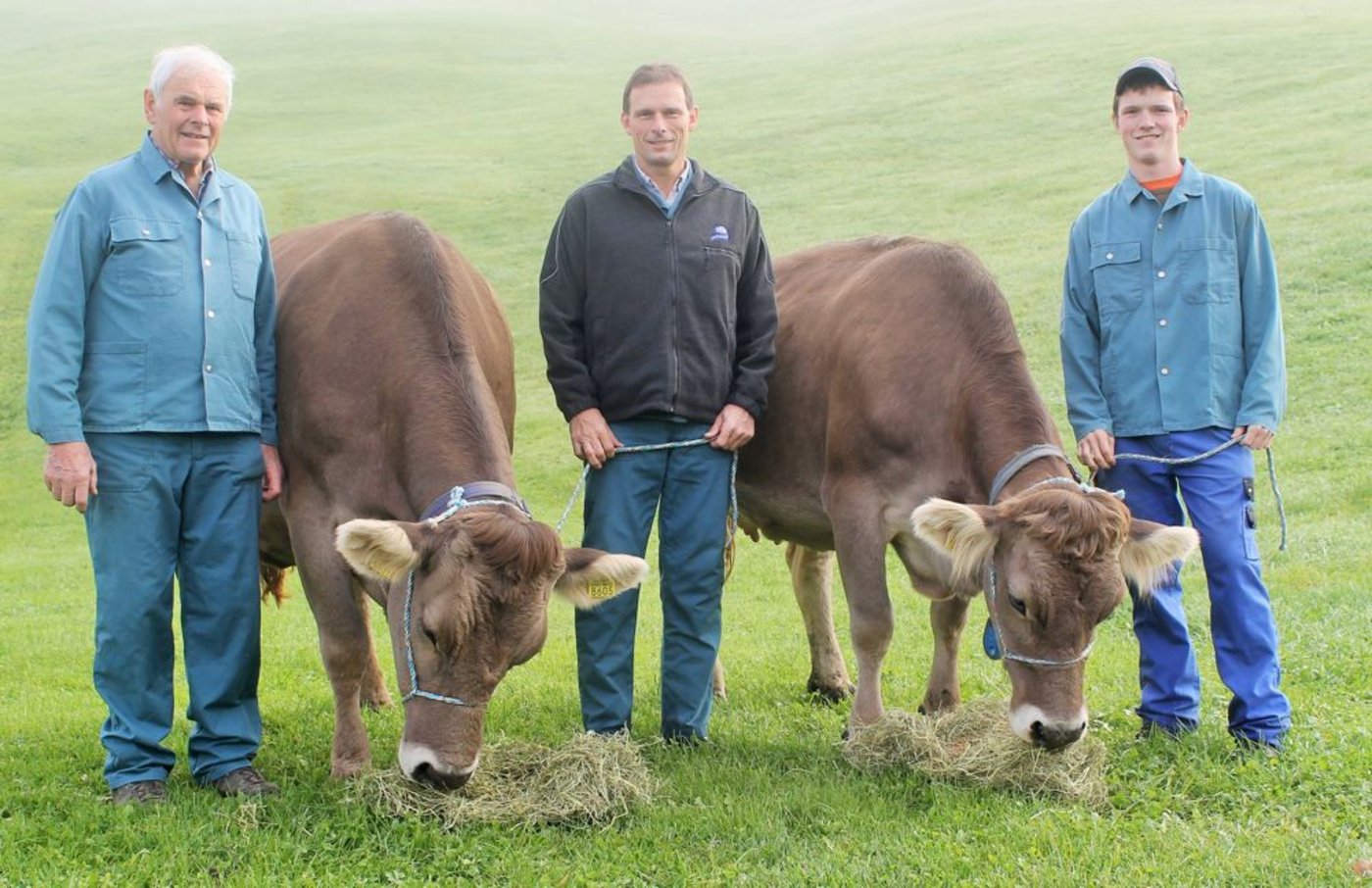 Drei Züchtergenerationen auf dem Betrieb Egli: Vater Hans, Betriebsleiter Hanspeter und Sohn Silvan mit ihrer Schöneutersiegerin Kroni und der Miss Raja. (Bild: Reto Betschart)