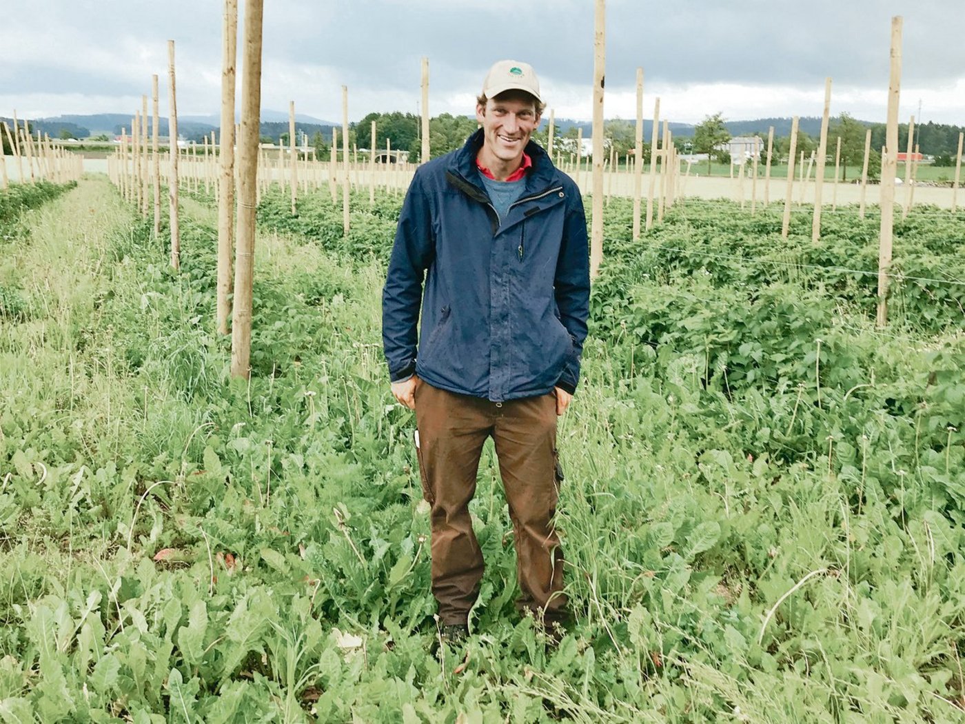 Simon Briner vor seinem Himbeerenfeld: Die Pfosten für das Schutzdach sind bereits eingeschlagen, auf die Blüte hin wird es fertiggestellt. Im Herbst schliesslich kommen Bäume für den Agroforst dazu.(Bild Alexandra Stückelberger)