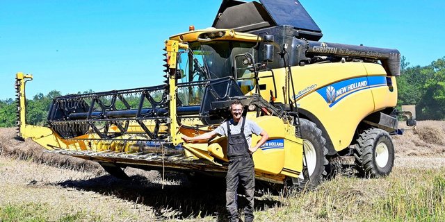 Lukas Christen vor einem seiner drei Mähdrescher.