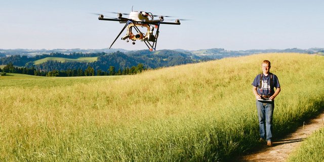 Ein Multikopter mit Wärmebildkamera beim Absuchen einer Heuwiese. (Bild Rehkitzrettung Schweiz)