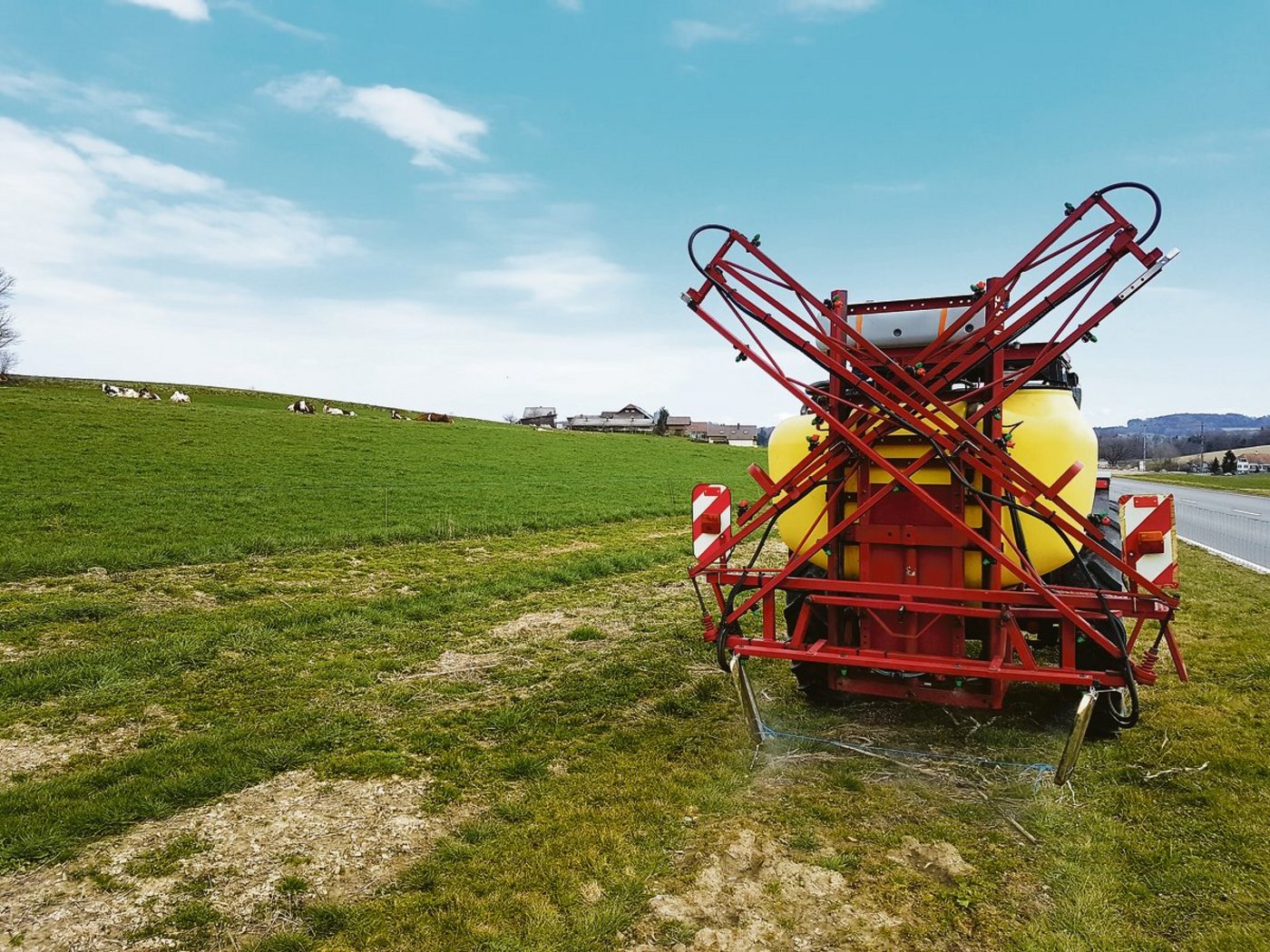 Mit einer improvisierten Einrichtung werden die Blumenbeete im Band gespritzt.(Bild Benno Jungo)
