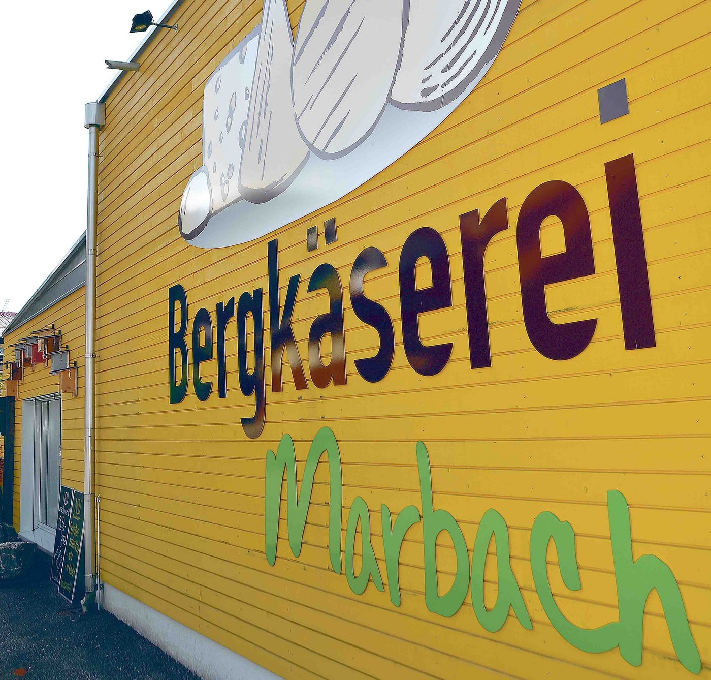 Mit neuer Strategie und dank Fabrikationsaufträgen auf Kurs: Produktionsgebäude mit Laden der Bergkäserei Marbach. (Bild aem)