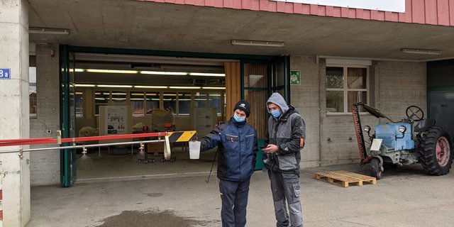 Gabriel Freis Kameraden stoppen die Zeit und messen die Ausbringmenge der Spritze im ÜK am Strickhof. (Bild Gabriel Frei)