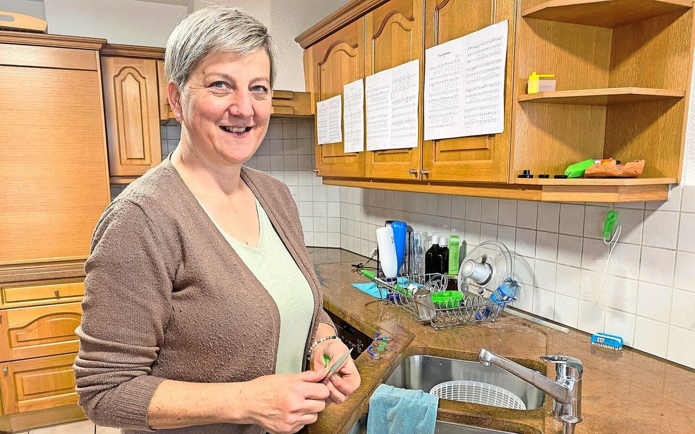 Sandra Bucher hat die Jodellieder an die Küchenschränke geheftet und übt während des Rüstens. 