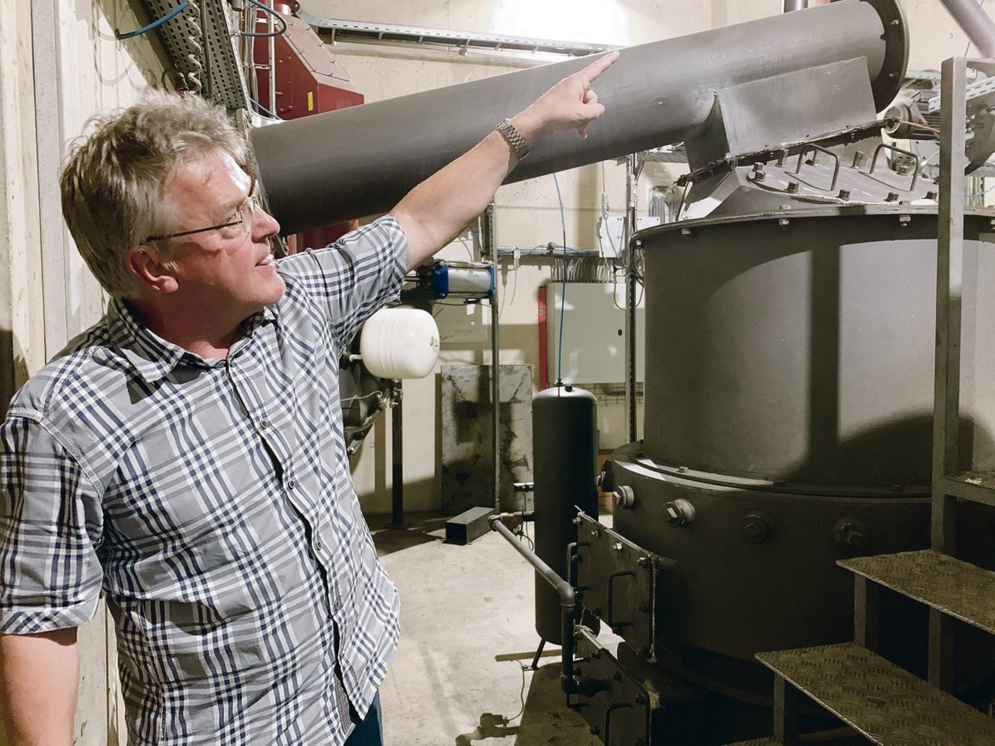 Hansjörg Bucher erklärt die Funktion des Holzvergasers. Darin werden die Schnitzel bei über600 Grad vergast. (Bilder Josef Scherer)