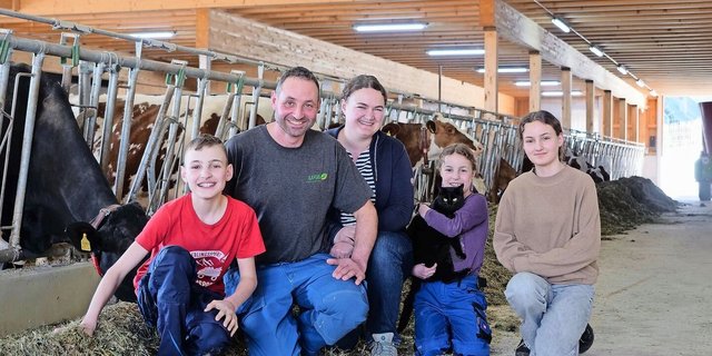 Michael und Katrin Stalder mit ihren Kindern Manuel, Salome und Lena (v.r.n.l.) im neu gebauten Laufstall. Dank der neuen Technik wie Melk- und Mistroboter bleibt nun mehr Zeit für die Familie.