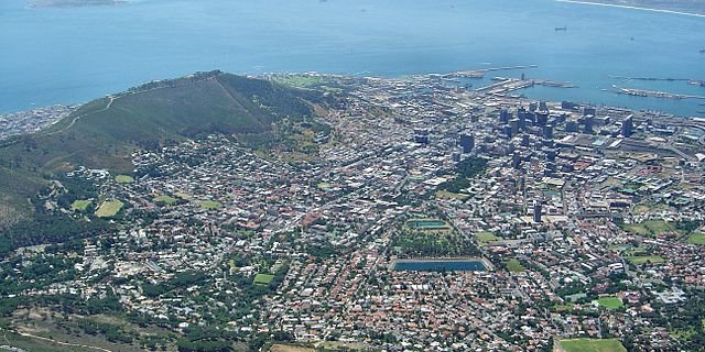 Blick auf Kapstadt mit dem Waterfront Harbour und Robben Island vom Tafelberg aus. (Bild Andreas Tusche - Wikimedia)