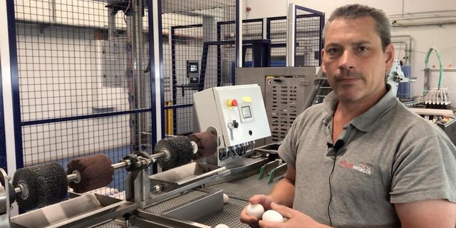 Markus Zürcher steht am Eiersortiertisch und erklärt den "Schöntal Ei Cleaner". dieser spart ihm einen Drittel der Arbeitszeit ein, die er und seine Mitarbeiterinnen zum Eier putzen benötigen.