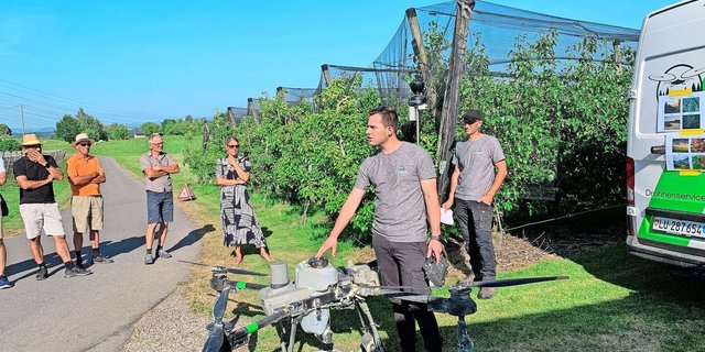 Philipp Schmidli und Martin Niederberger (r.) von den Agrarpiloten Zentralschweiz präsentieren den Weinbauern auf dem Betrieb vom Südhang in Eschenbach den Einsatz der Drohne für den Pflanzenschutz im Rebbau.