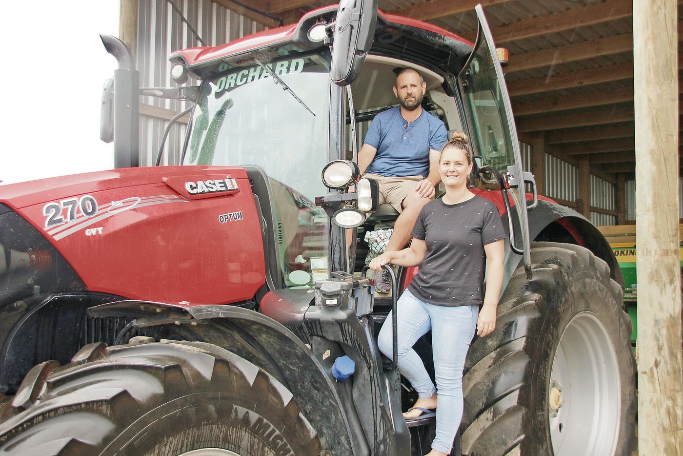Damian und Terese Orchard in ihrem Fuhrpark. Das Lohnunternehmen besitzt zehn Landwirtschaftsfahrzeuge wie Traktoren und Mähdrescher. Während Damian die Einsätze leitet und Maschinen repariert, macht Terese die Buchhaltung. (Bild Matthias Stadler)