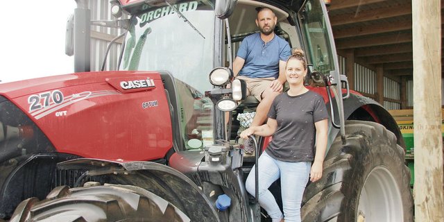 Damian und Terese Orchard in ihrem Fuhrpark. Das Lohnunternehmen besitzt zehn Landwirtschaftsfahrzeuge wie Traktoren und Mähdrescher. Während Damian die Einsätze leitet und Maschinen repariert, macht Terese die Buchhaltung. (Bild Matthias Stadler)