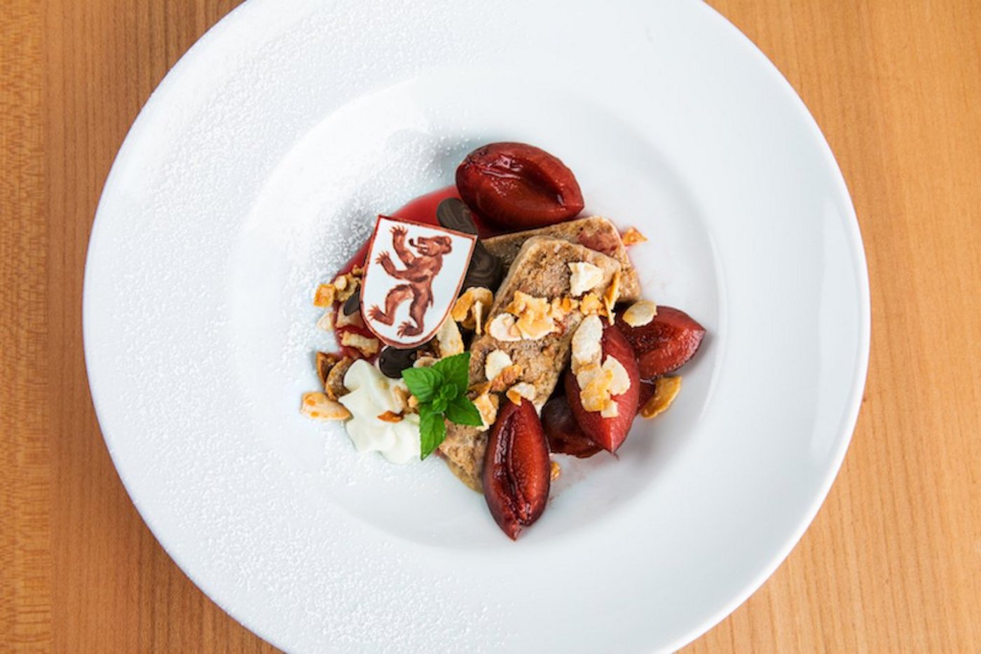 Biberfladenparfait mit heissen Rotwein Zwetschgen, Rahm und Zuckermandeln. (Bild Ueli Christoffel/SRF)