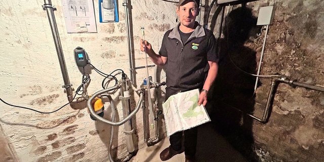 Werner Koller erklärt die Wasseraufbereitungsanlage im Keller seines Wohnhauses. In der rechten Hand hält er die UV-Lampe zur Reduzierung von Bakterien und Keimen. 