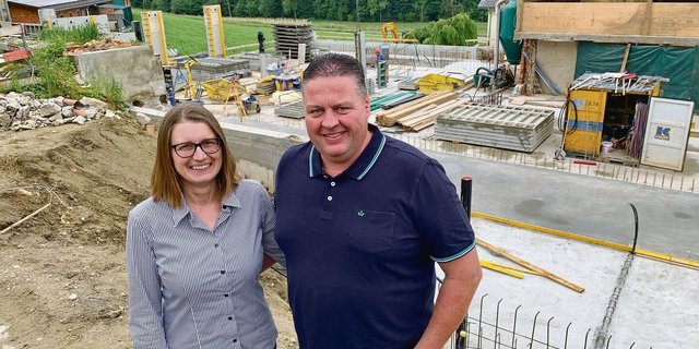 Natalie und André Frank auf der Baustelle für die neue Scheune. Hinten in der Mitte das neue Wohnhaus, links die Schweinescheune.