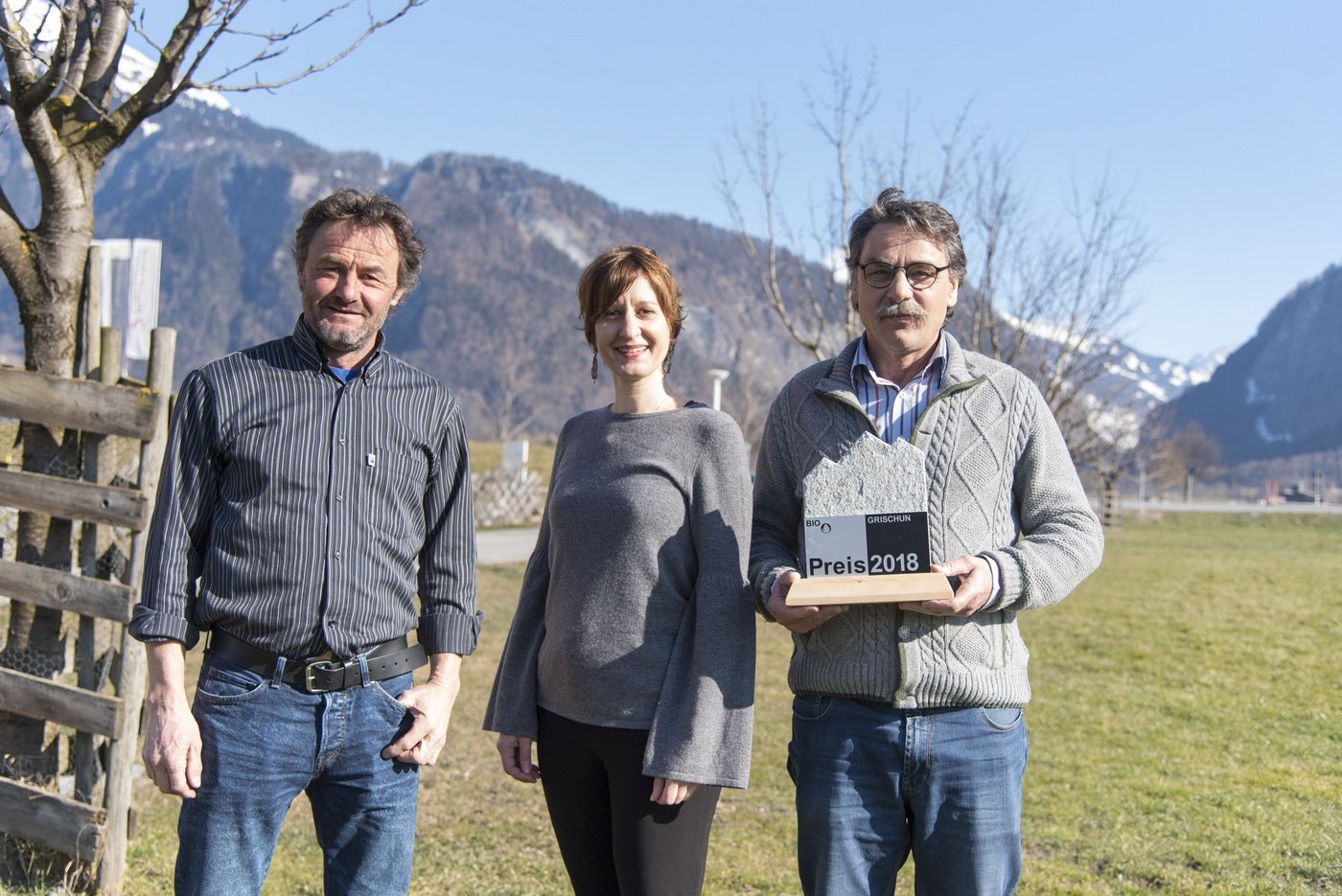 Bio Grischun-Präsident und Sängerin Martina Hug übergaben dem letztjährigen Sieger, dem Biokräuter-Pionier und Produzent für Ricola und den Direktverkauf, Reto Raselli, den Bio Grischun PreisPreis. (Bild ZvG)