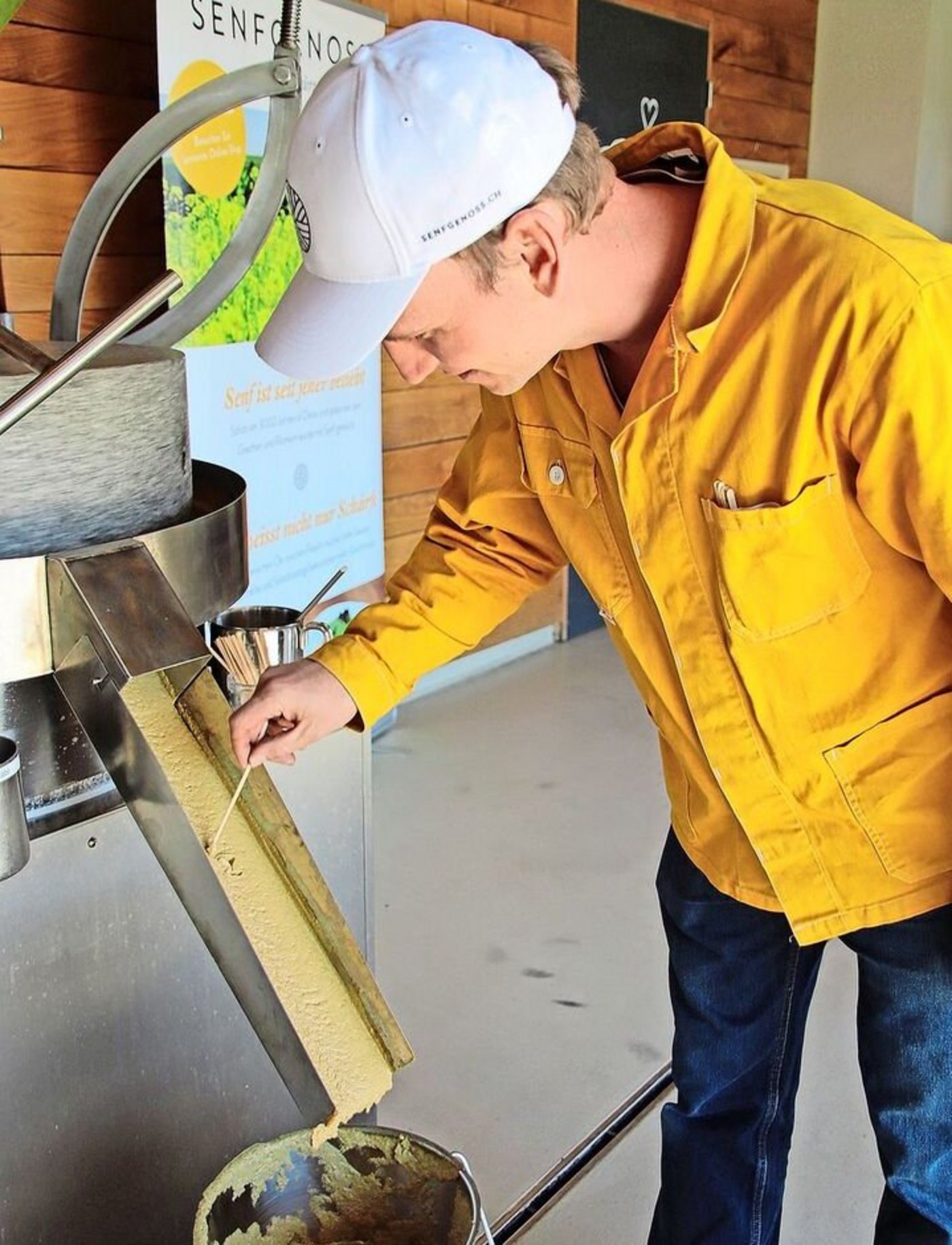An der Senfmühle: Ueli Kilchsperger überprüft die Senfmasse nach dem Mahlvorgang.