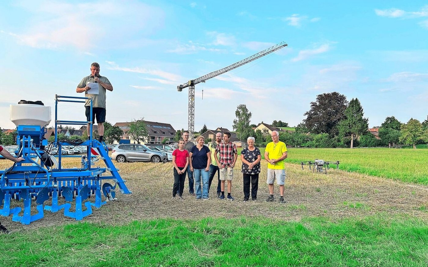 Die Gastgeber am Puure-Höck (v. l.): Martin Berger (mit Mikrofon), Tochter Leonie mit Rahel Berger, hinter ihnen Marc Peter (Präsident Bezirksverein Winterthur), Thomas Kyburz, Florian Berger, Lotti Berger und Markus Kyburz.