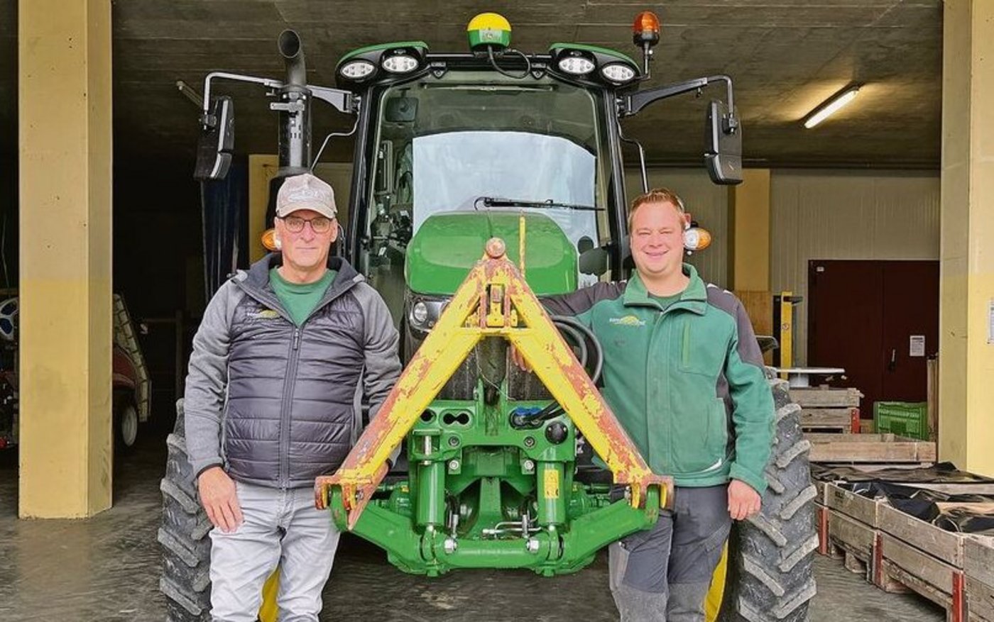 Thomas (links) und Marc Grüter stehen vor einem ihrer John Deere-Traktoren.