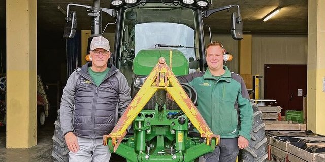Thomas (links) und Marc Grüter stehen vor einem ihrer John Deere-Traktoren.