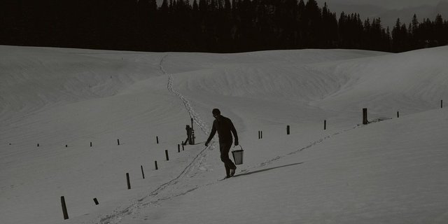 Mätthu füllt Eimer mit Wasser aus den Rohren, die er mitverlegt hat.