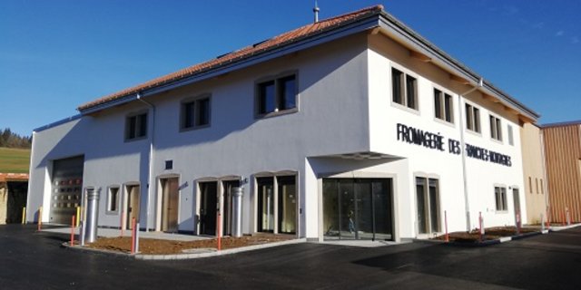 Die neue Käserei in Le Noirmont JU ist ein moderner Neubau mit Robotern im Keller und Solarplatten auf dem Dach. (Bild Fromagerie des Franches-Montagnes)