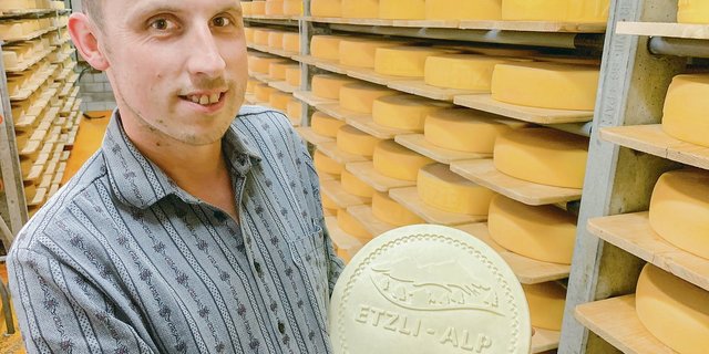 Stolz präsentiert Daniel Ulrich im Käsekeller den Etzlialp Käse, erstmals mit eigenem Siegel.  (Bild Josef Scherer)