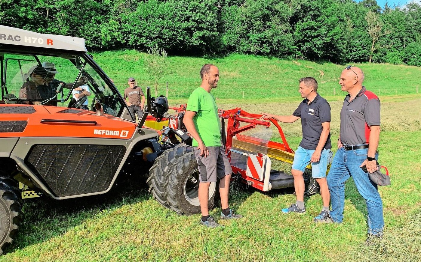 Reto Hurter von HW Landtechnik in Buonas, Andreas Enzler von Agromont und René Wismer, Inhaber HW Landtechnik (v.l.)  beim Bandschwader von Pöttinger, angehängt am Reform H70 R. 