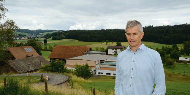 Die Bauphase ist abgeschlossen: Franzsepp Erni mit  Hofgruppe im Hintergrund. Der Stall für die 100 Muttersauen ist zweistöckig und wirkt kompakt. (Bilder Armin Emmenegger)