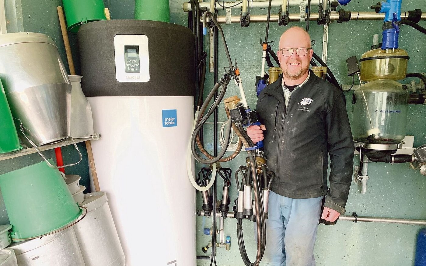 René Niederberger konnte dank vielen Eigenleistungen die Kosten für die Installation der Wärmepumpenboiler im Milchraum (l.) tief halten. 
