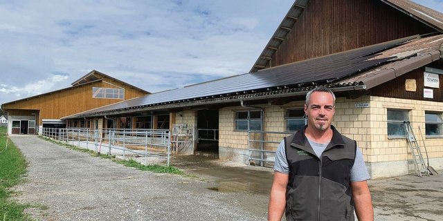 Stefan Troxler vor der 2013 erstellten Solaranlage auf dem Scheunendach. Diese wurde 2021 auf eine Leistung von 130 kWp erweitert. Der meiste Solarstrom muss ins Netz abgegeben werden.  