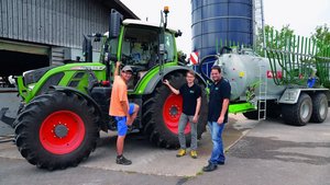 Swiss Future Farm in Tänikon Flavio Näf (links), Florian Abt (Mitte) und Marco Landis (rechts) von der Swiss Future Farm stehen vor dem Traktor, an dem ein Güllefass angehängt ist.