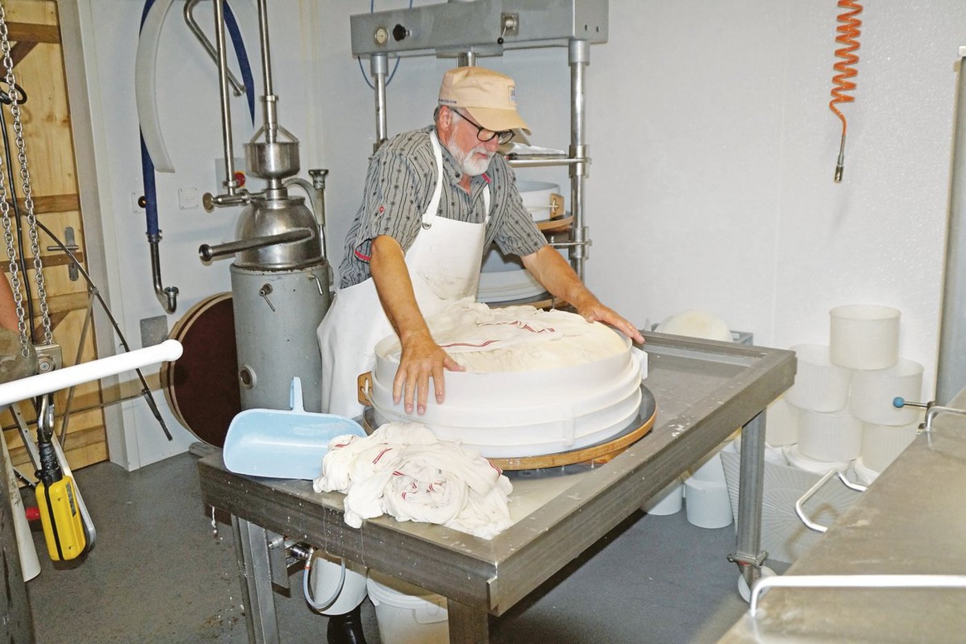 Käsermeister Bernard Schneuwly hat den Käsebruch soeben in die Form gepasst. Alle Beteiligen sind glücklich darüber, wie der erste Alpsommer in der neuen Käserei gelaufen ist. (Bild Josef Jungo)