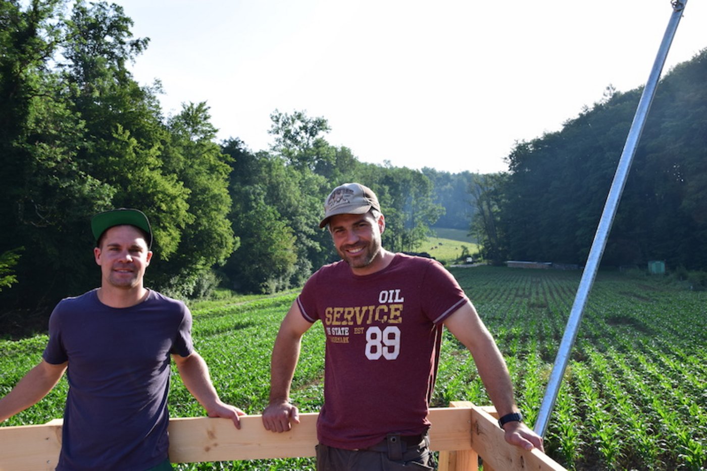 Andreas Benz (links) und Andreas Sozzi stehen lachend auf ihrer selbsterbauten Terrasse. Bald erwarten die beiden Besucherinnen und Besucher, die sich in ihrem Maislabyrinth (nicht) verirren wollen. (Bild lko)