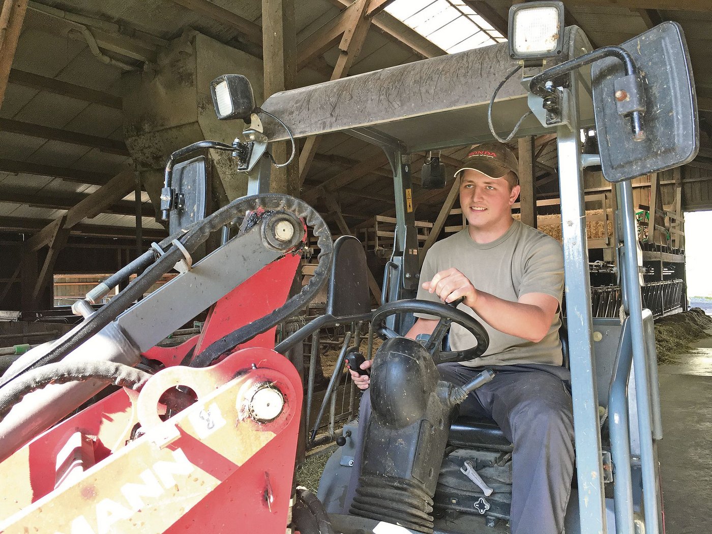 Ivan Heller mit dem Hoflader im Milchviehstall. Er blieb noch ein paar Wochen länger auf seinem Lehrbetrieb, um beim Stallumbau mitzuwirken.  (Bild Armin Emmenegger)