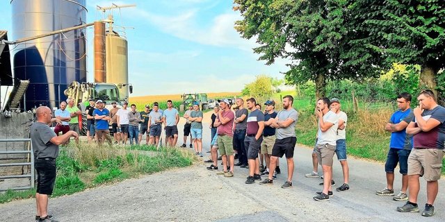 Martin Uhlmann (links) stellt den Junglandwirtinnen und Junglandwirten die Betriebsphilosophie vor. 