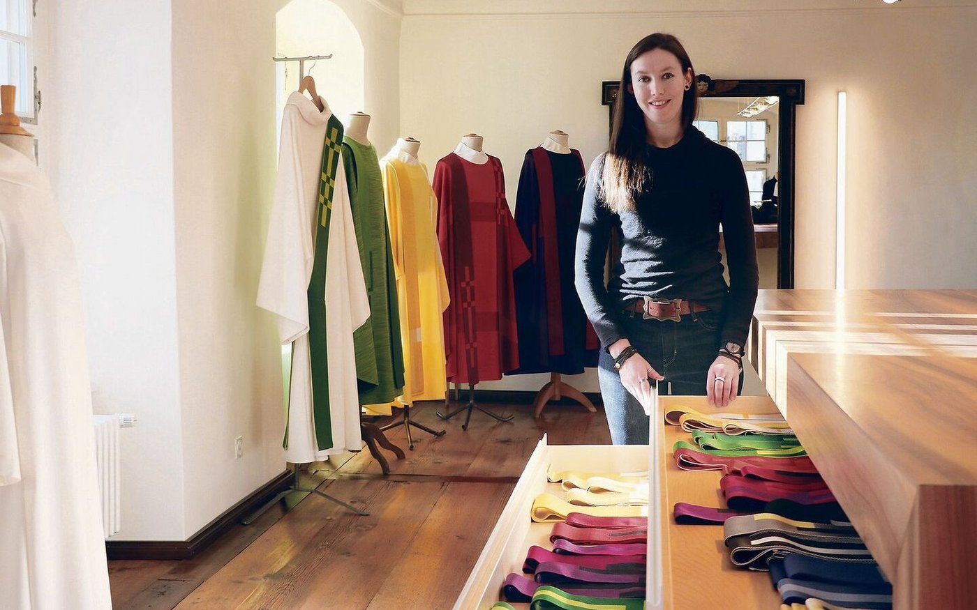 Zoe Wüst im Showroom der Paramenten-Werkstatt. Hier berät die gelernte Weberin und Schneiderin Kundinnen und Kunden bei der Wahl von Stoffen und Schnitten.