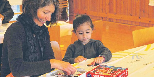 Eine Landfrau spielt mit einem Flüchtlingskind: Im Gemeinde-Mehrzweckraum konnten gemütliche Stunden verbracht werden. So rückten Krieg und Flucht kurz in den Hintergrund. (Bilder S. Gasser)
