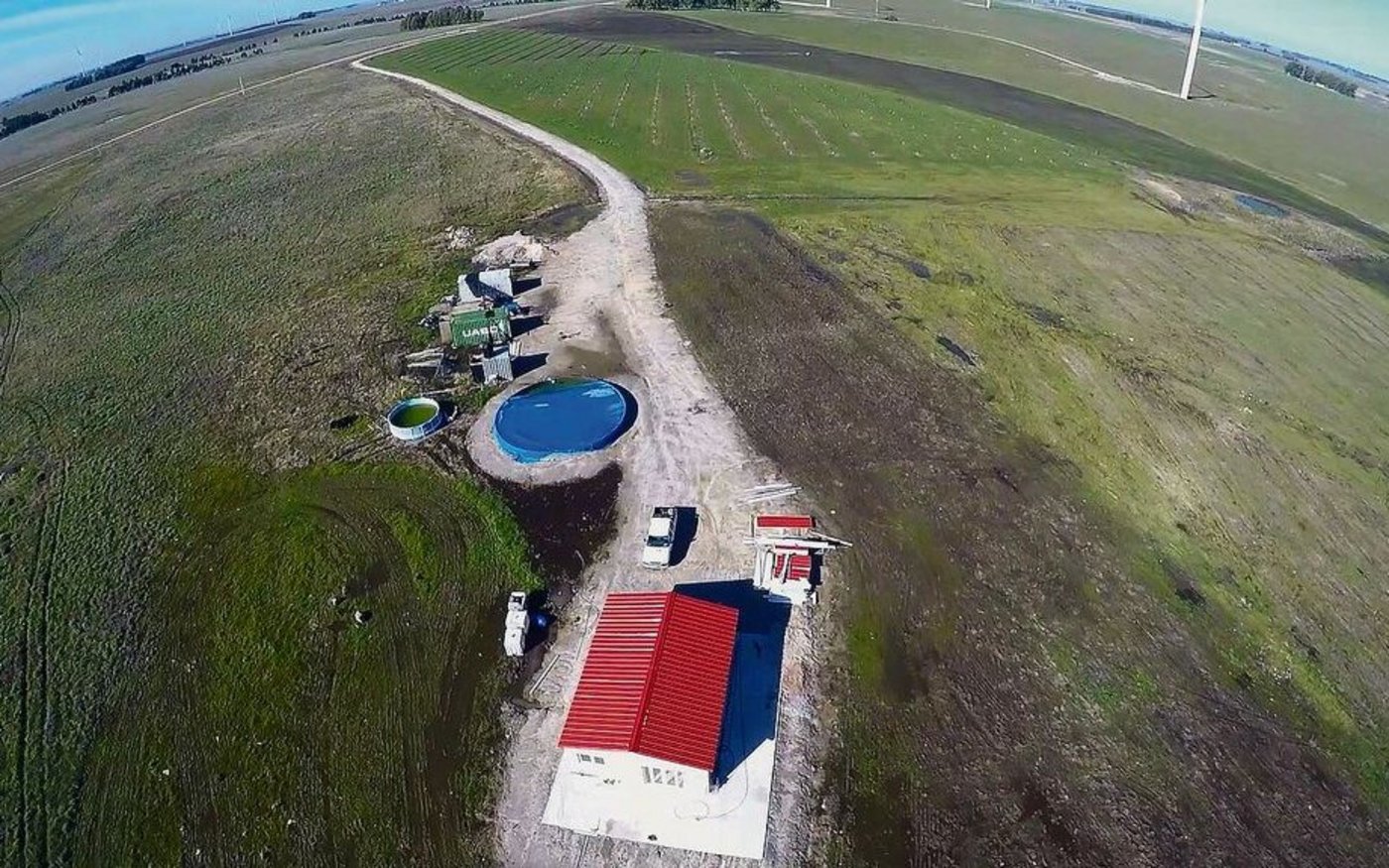 Wohnhaus, Container und Wasserreservoir sowie im Hintergrund die Linien mit den ersten Pekanbäumen. 