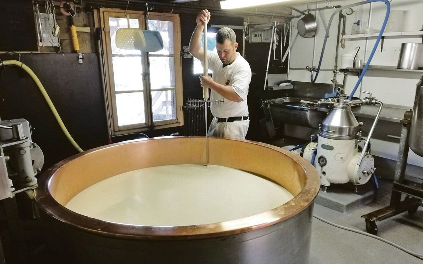 Adrian Schenk beim Käsen. Heuer haben die beiden Familien auf der Alp Rämisgummen 13 Tonnen Alpkäse produziert.