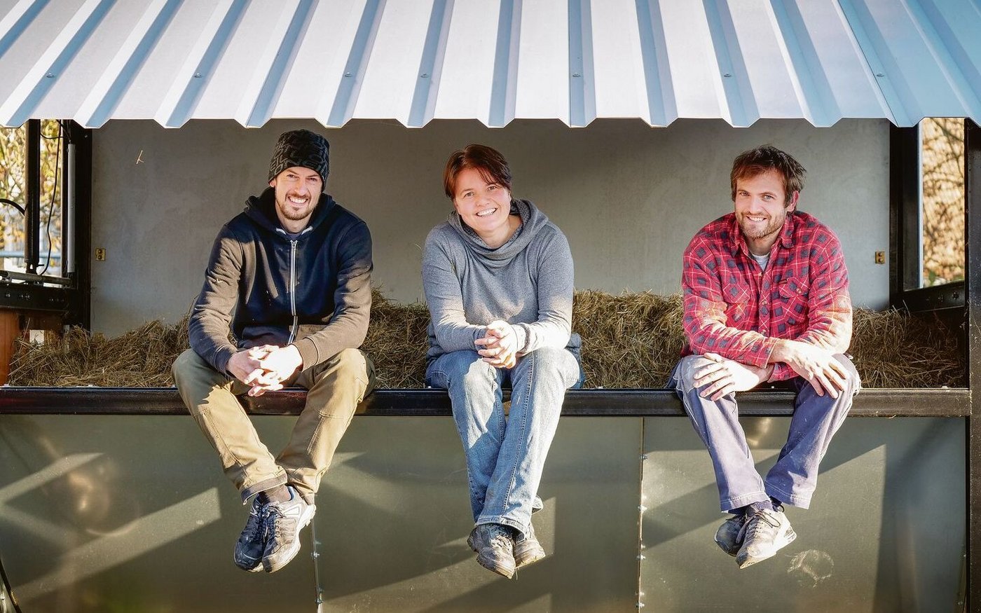 Frank und Cornelia Stelzer und Philipp Fürst (v.l.) sitzen in der Heuraufe..