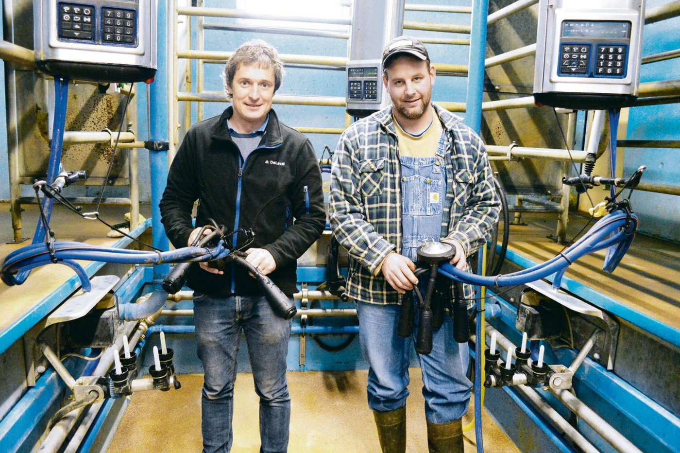 Urs Schmid (links), Produktleiter bei DeLaval in Sursee LU, im Stall bei Lionel Kolly aus Pont-la-Ville FR, der das neue Evanza-Melkzeug als Pilotbetrieb seit zwei Monaten nutzt.  (Bilder Peter Fankhauser)