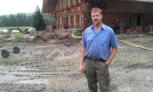 Der Brunnen wurde vom Wasser davon getragen, ebenso das Jauchefass. Landwirt Hans Gerber gestern Mittwochmorgen vor dem Bauernhaus. Wasser und Schlamm liefen durch die Gebäude (nächstes Bild) ... (Bilder: Simone Barth)