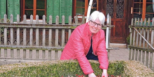 Helen Ruch-Sommerhalder vor ihrem Berner Bauernhaus, wo bereits die Frühlingsblumen blühen.  Da sie nicht gerne einkauft, zieht sie auch selber  Gemüse für die Selbstversorgung. (Bild Barbara Heiniger)
