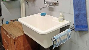 Keramikplatten im Be Keramikplatten im Bereich des Lavabos lassen sich leicht reinigen. Ablagen für Reinigungsmittel und Utensilien sorgen für Ordnung.