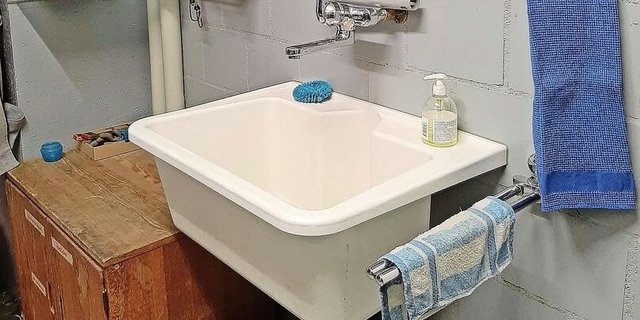 Keramikplatten im Bereich des Lavabos lassen sich leicht reinigen. Ablagen für Reinigungsmittel und Utensilien sorgen für Ordnung.