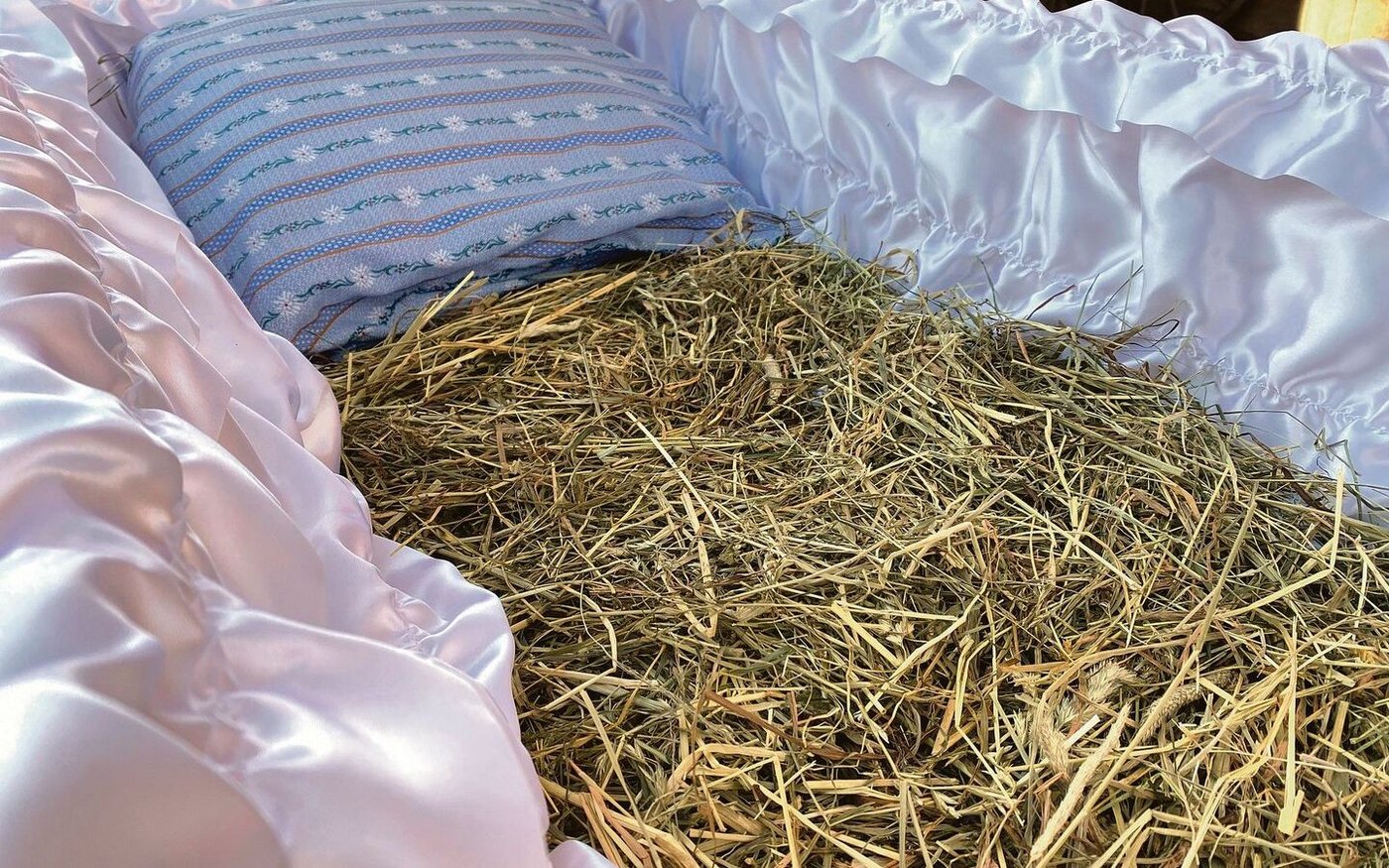 Blick in den speziellen Sarg, in dem man die ewige Ruhe auf Emmentaler Heu und einem Kissen mit Edelweissmuster findet.