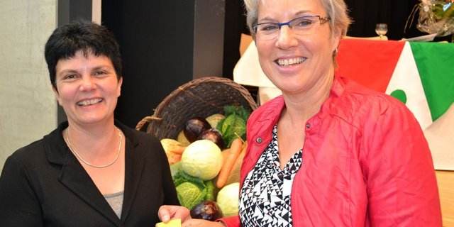 Yes, we can! Die abtretende Präsidentin Christine Gerber (links) übergibt ihrer Nachfolgerin Rita Gfeller in der Mehrzweckhalle in Ins ihr Glücksbringer-Nastüechli, das sie 2008 bei ihrem Amtsantritt erhielt.  (Bild Alois Heinzer)